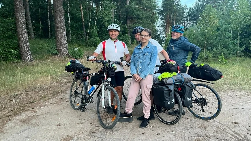 Trzej muzycy klasyczni jadą rowerami przez Mazury